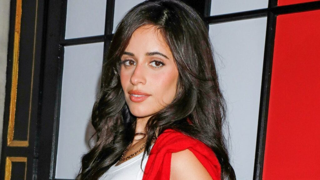 Camila Cabello puts a flirty twist on preppy style in a red knit mini skirt and sky-high white boots