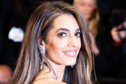 Amal Clooney has a bridal moment in slinky white dress with flowers in hand beside George in Lake Como