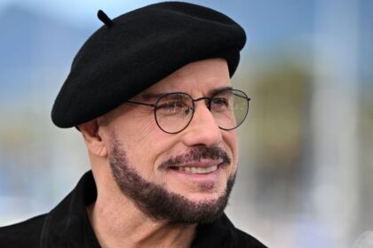 John Travolta pairs his iconic beret with a leather jacket for a Ramones tribute