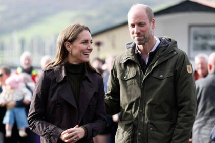 Prince William and Princess Kate get their hands dirty at the beach during horizontal rain