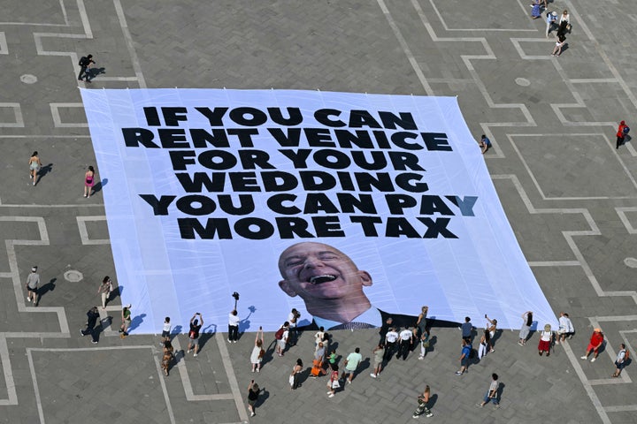 Activists with the international environmental group Greenpeace deploy a giant banner displaying a picture of Jeff Bezos on Monday.